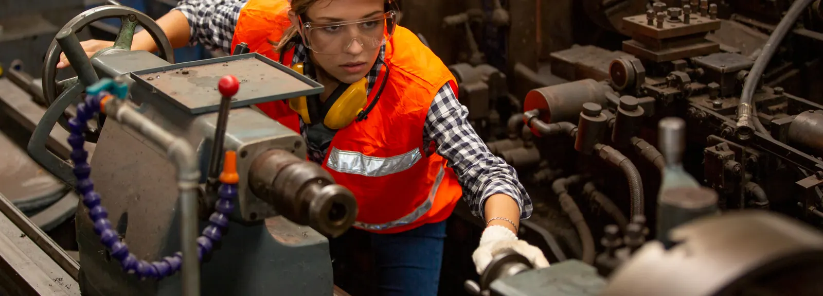 Engineer operating a lathe on the factory floor